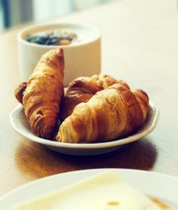 einen Teller mit zwei Croissants und einer Tasse Kaffee in der Unterkunft Hotel De L'aeroport in Alger