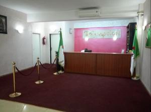a lobby with a reception desk and a flag at Hotel De L'aeroport in Alger