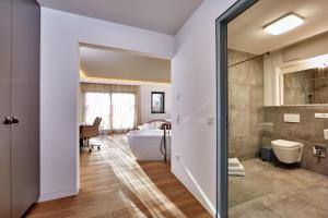 a bathroom with a tub and a toilet and a sink at City Suites Murnau in Murnau am Staffelsee +153 photos
