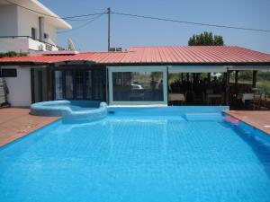 a large blue swimming pool with a red roof at Blue Sky in Frangokastello