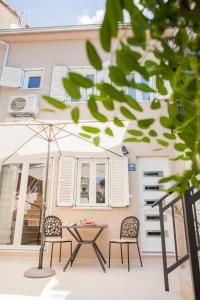 a patio with two chairs and a table in front of a building at Marijola apartments in Šibenik