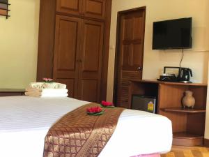a hotel room with a bed and a flat screen tv at Phi Phi Villa Resort-SHA Extra Plus in Phi Phi Islands