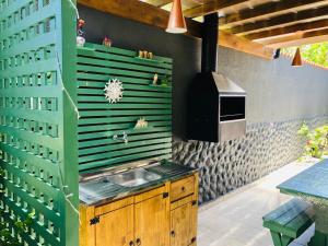 a kitchen with a sink and a stove at Casa Cheia de Alegria e Sol in Peruíbe