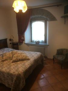 a bedroom with a bed and a window and a chair at Affittacamere L'Abri in Etroubles