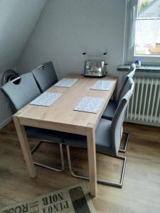 Ferienwohnung Sonneneck في Scharzfeld: طاولة خشبية مع كرسيين وراديو عليها +3 صور