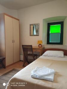 a bedroom with two beds and a desk and a green window at Guest House Fosa in Opuzen