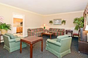 a living room with couches and chairs and a television at Motel 6 Sandersville, GA in Sandersville