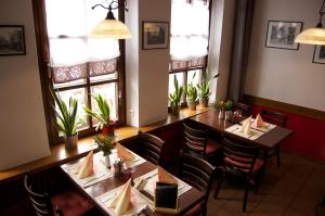 una sala da pranzo con tavoli, sedie e finestre di Ferienwohnung Om Maat a Erpel