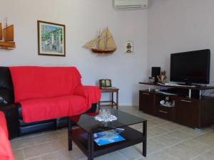 a living room with a red couch and a tv at Tower Suites Korcula in Korčula