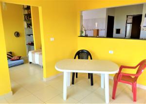 a dining room with a white table and two chairs at Casa Beira Mar in Jacumã