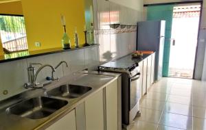 a kitchen with a sink and a refrigerator at Casa Beira Mar in Jacumã