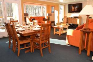 comedor con mesa de madera y sillas en Luxurious Trailside Village One Bedroom Condo #1, en Killington