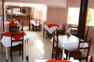 a dining room with tables and chairs in a restaurant at Rede Andrade Porto Seguro in Porto Seguro