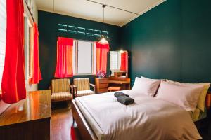 a bedroom with a large bed with red curtains at Heahtitude - Children Not Allowed in Cameron Highlands