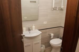 a bathroom with a sink and a toilet and a mirror at Easy House in Naples +26 photos