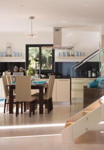 a kitchen and dining room with a table and chairs at Luxury Ocean Front Villla in Calheta