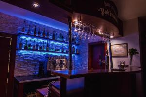 a bar with blue lights and bottles on the wall at Hotel Pod Hradom in Trenčín