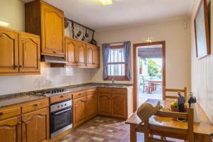 a kitchen with wooden cabinets and a table in it at Can Agustín in Santa Gertrudis de Fruitera