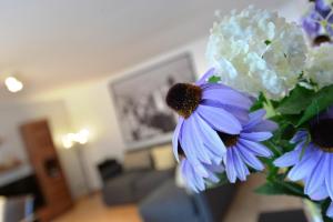 a vase with purple and white flowers in a living room at Haus Daniela Superior in Cochem