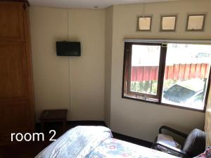 a bedroom with a bed and a window at Villa Klub Bunga, 3 BDR with kid's pool in Batu