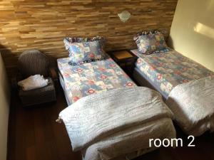 a room with two twin beds and a chair at Villa Klub Bunga, 3 BDR with kid's pool in Batu +14 photos