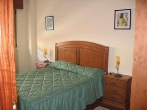 1 dormitorio con 1 cama con edredón verde en EN PLAYA SAN VICENTE DE LA BARQUERA, en San Vicente de la Barquera
