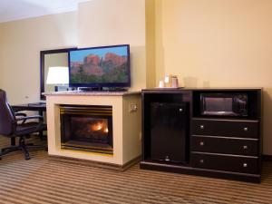 Habitación de hotel con chimenea y TV. en Desert Quail Inn Sedona at Bell Rock en Sedona