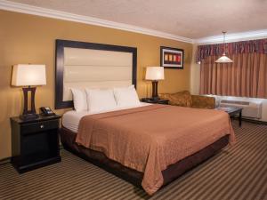 セドナにあるデザート クエイル イン セドナ アット ベル ロックのベッドとリビングルームが備わるホテルルームです。