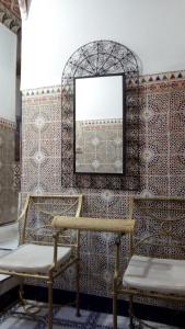 Habitación con 2 sillas y espejo. en Hotel Medina en Marrakech