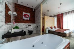 a bathroom with a large tub and a bedroom at Loft Garden in Saint Petersburg