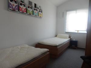 2 camas individuales en una habitación con ventana en Beim Kellerschneider OG, en Gundelfingen