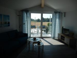 a living room with a couch and a table and a window at Beim Kellerschneider OG in Gundelfingen