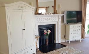 a living room with a fireplace and a television at Longworth Hall Hotel in Hereford