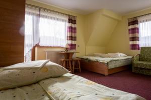 a bedroom with two beds and a chair and windows at DW Lassakówka in Suche