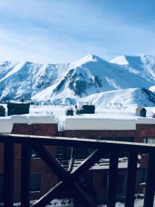 een met sneeuw bedekte berg met een trein ervoor bij Golden Mount View Apartment in Goedaoeri
