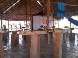 a group of tables in a straw umbrella at Refúgio Raiz Camping in Carolina