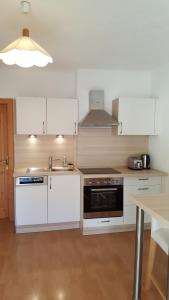 uma cozinha com armários brancos, um lavatório e um fogão em Appartement Stubaital em Neustift im Stubaital