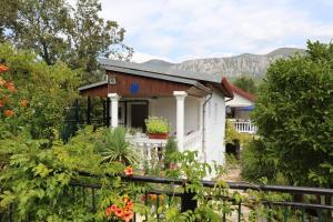 a small white house with mountains in the background at Villa Behija Ferienwohnung 2 Crikvenica in Crikvenica