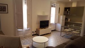 a living room with a couch and a tv at Apartamentos Nouvilas in Portbou