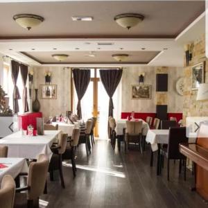 a dining room with white tables and chairs at Milmari, Resort, Premier Apartman A52 & Parking garage FREE in Kopaonik