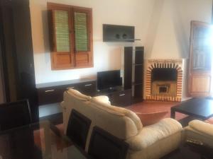 sala de estar con sofá y chimenea en Finca Casa Grande, en Tavernes de Valldigna