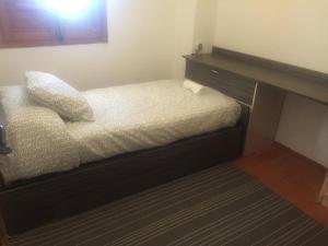 a small bedroom with a bed and a desk at Finca Casa Grande in Tavernes de Valldigna