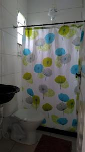 a shower curtain with umbrellas on it in a bathroom at Apto Praia de Setiba 2 in Guarapari