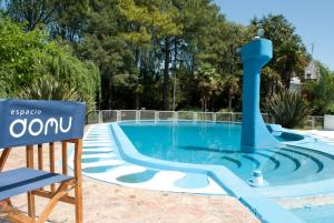 a sign sitting next to a swimming pool at Espacio Domu in Cañuelas