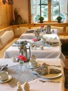 a group of tables with white tablecloths and plates at Abendblume in Leavenworth