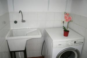 a bathroom with a washing machine and a sink at Vivienda Vacacional La Laguna Deluxe 2 in Las Lagunas