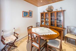 a dining room with a wooden table and chairs at Casa da Vila in Albufeira