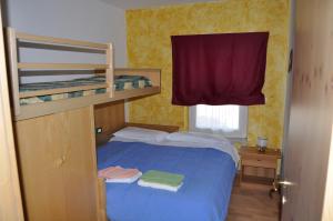 a small bedroom with a blue bed and bunk beds at Silvano Fanti in Rumo