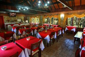 a restaurant with red and white tables and chairs at Pousada Serras De Monte Verde in Monte Verde