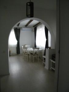 a dining room with an archway with a table and chairs at Iarca Cottage in Bucharest